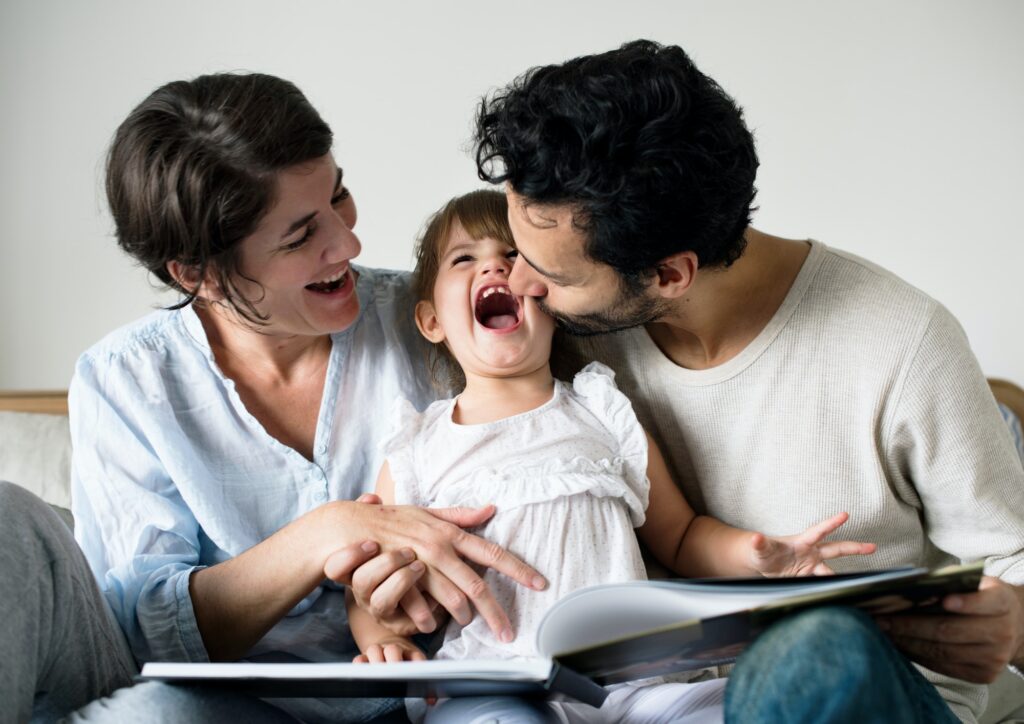 Happy parents laughing together with daughter